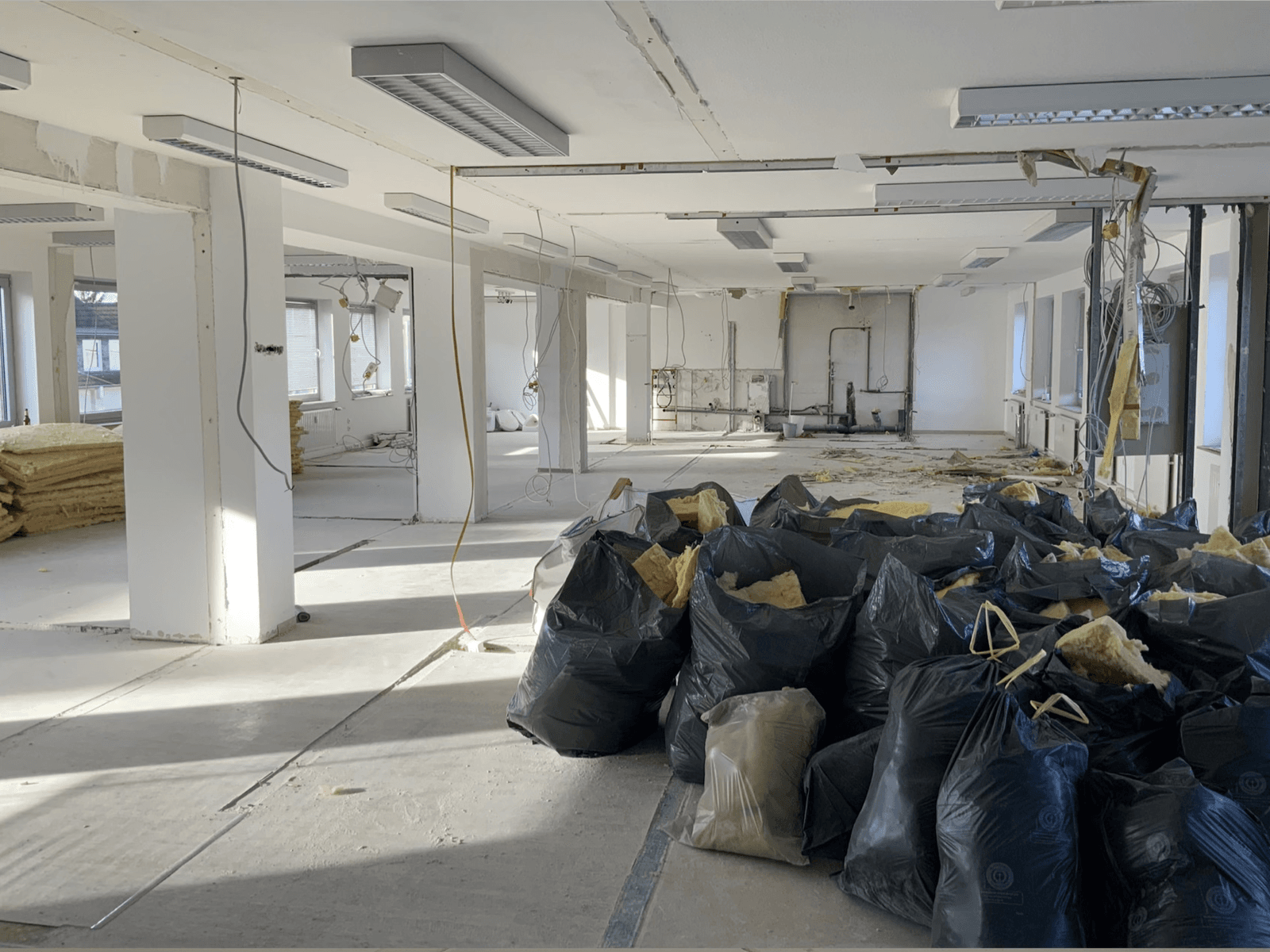 Gewerbefläche im Rohbau- und Entkernungszustand mit Bauschutt und Deckenarbeiten
